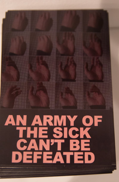 A four by four grid of photographs showing a progression of my cramping hand, sometimes noticeable, sometimes defiant and always cramping, on a grey background with pink bold text below the images that says An Army Of The Sick Can’t Be Defeated.
